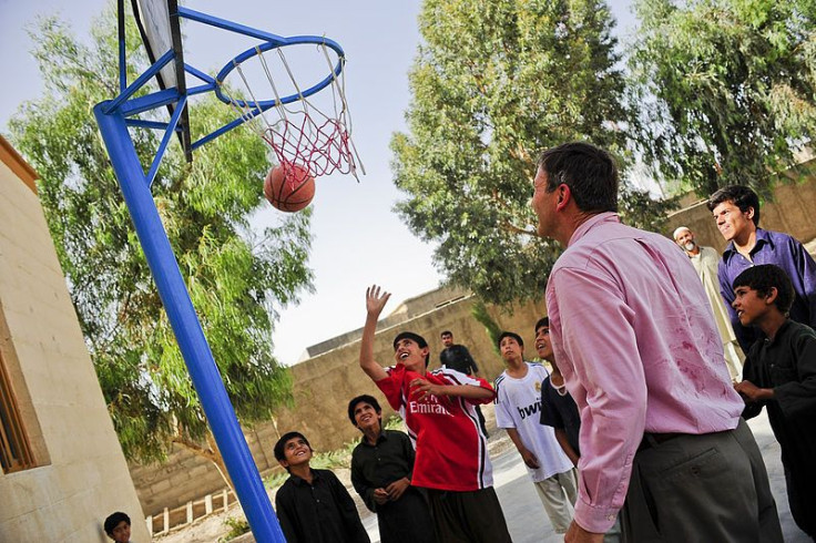 Kids playing basketball with man
