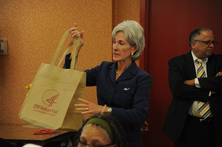 Health Secretary Kathleen Sebelius holds up a &quot;Stop Medicare Fraud&quot; tote bag