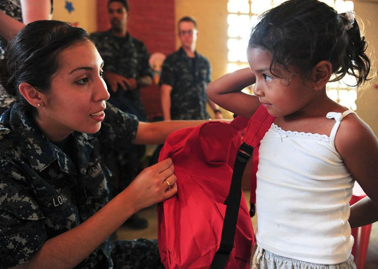 Sailor helps a student in Ecuador with a donated backpack
