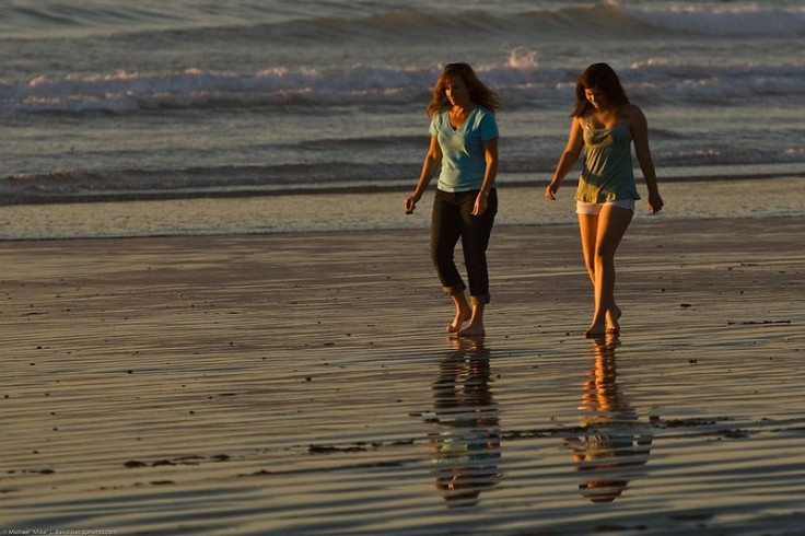 Mother and daughter walking on beach