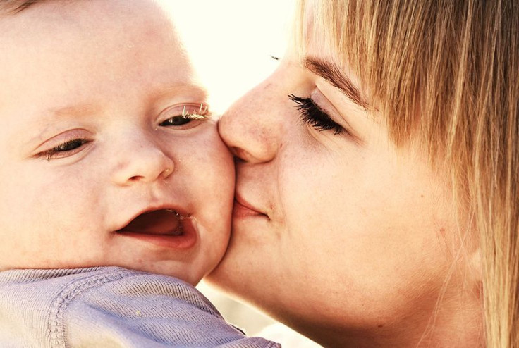 Mom kissing baby on cheek