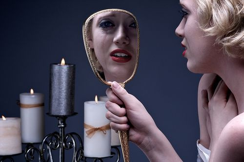 Crying woman looking into mirror
