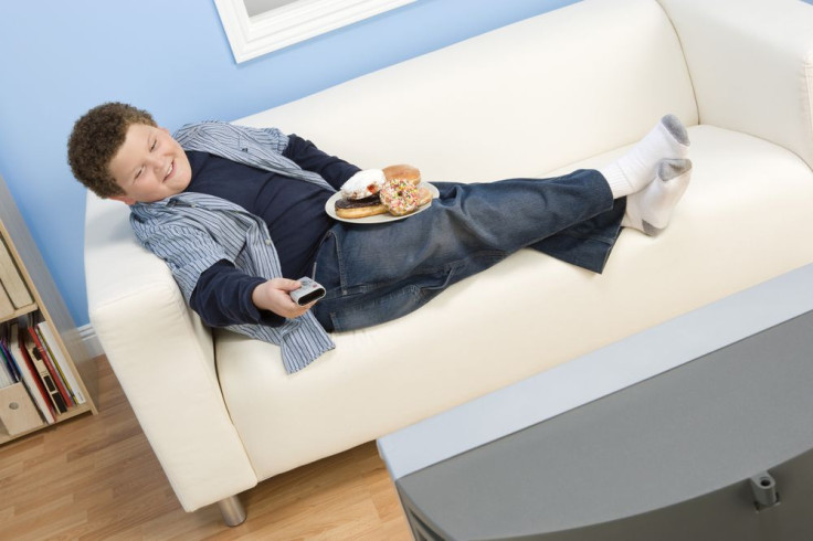 Boy watching TV and eating on coach