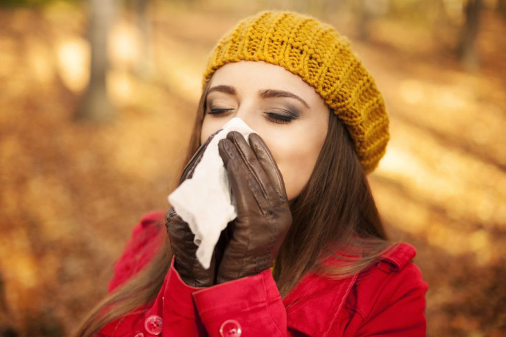 Woman sneezing outside