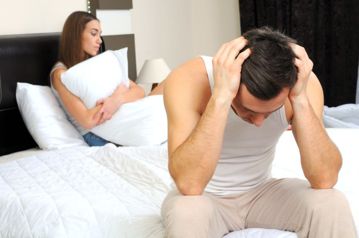 Upset man having problems with girlfriend in bedroom