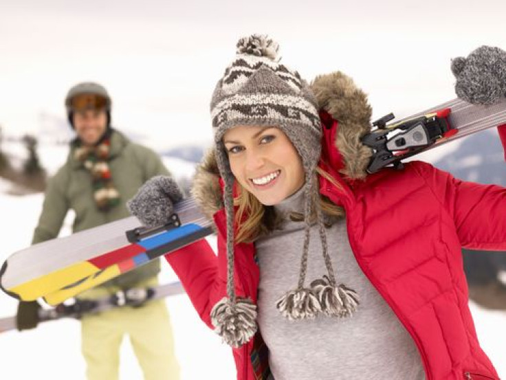 Woman holding skis on slope