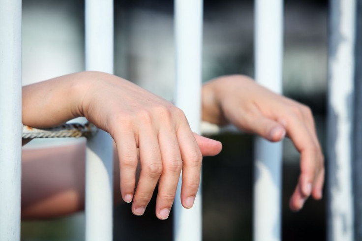 Hands of inmate behind bars