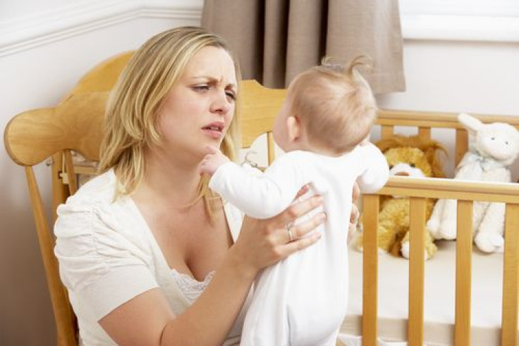 Stressed mother holding baby in nursery