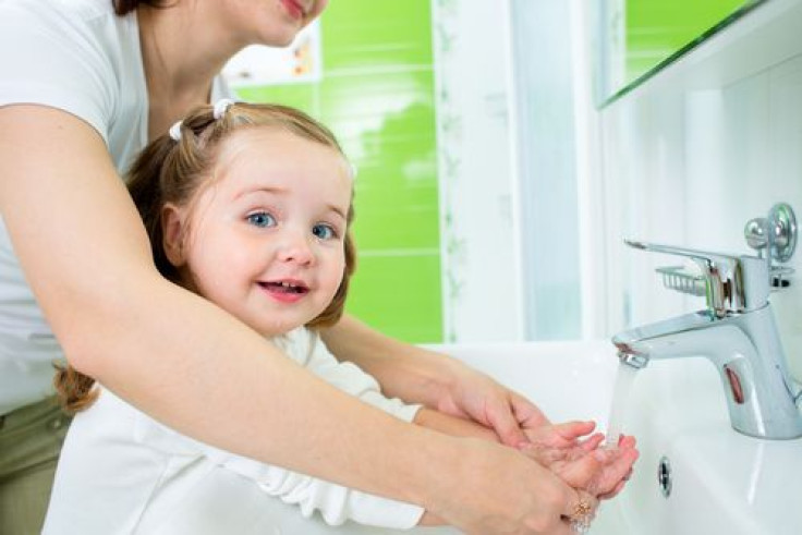 Mother washing kids hands