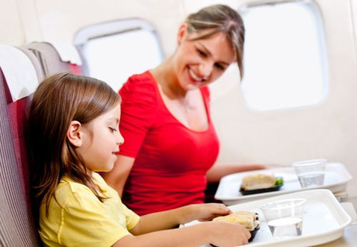 Mother and son having in-flight food on plante