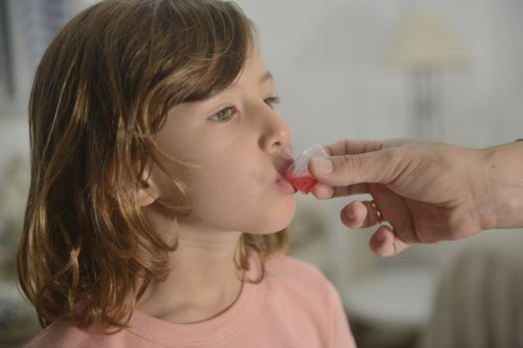 Little girl taking cough syrup