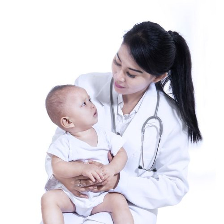 Female doctor holding baby