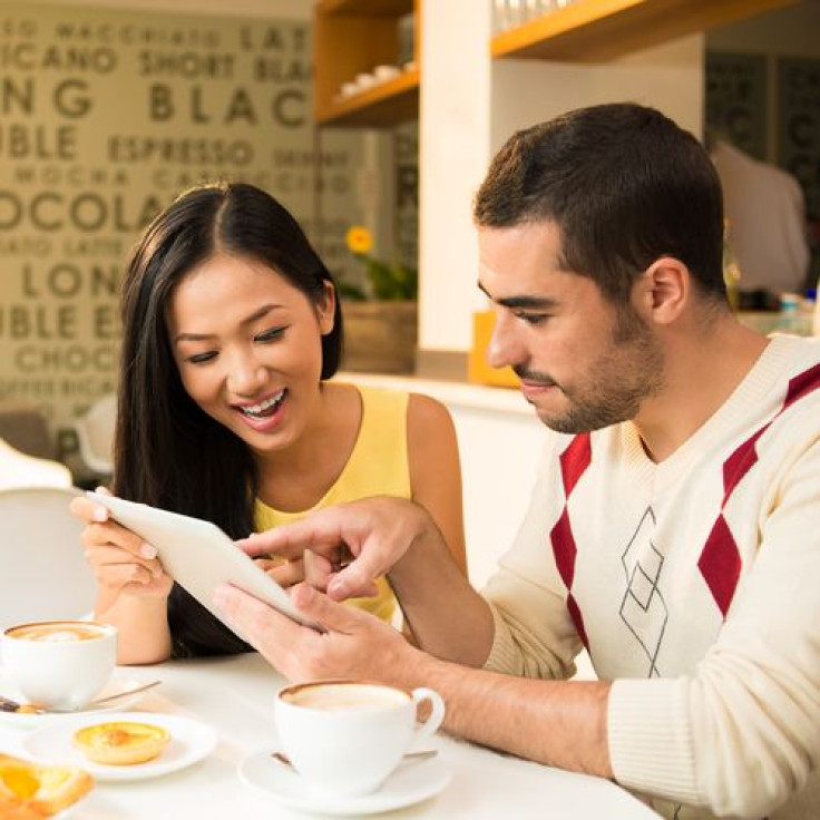 Man and woman networking with the digital tablet at a cafe