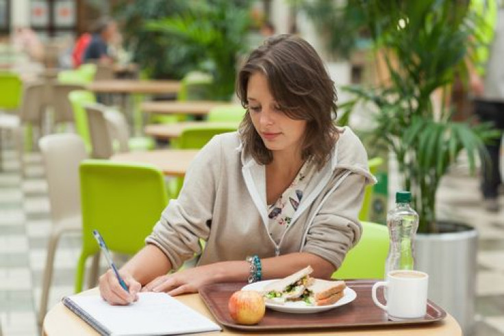 Student doing homework while having breakfast in the cafeteria