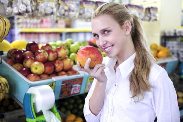 Woman smelling mango at the supermarket 