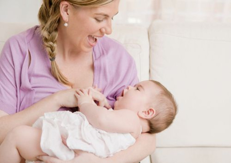 Mother playing with baby in her arms