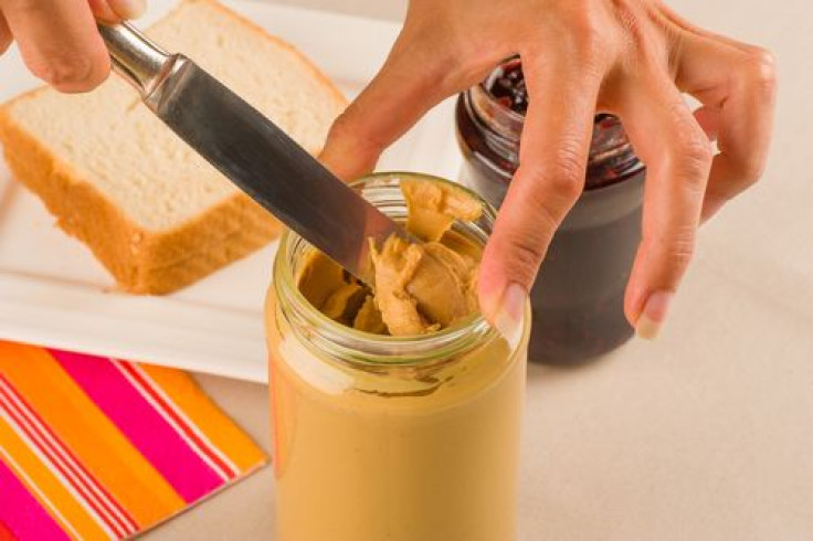 Woman about to spread peanut butter on sandwiches
