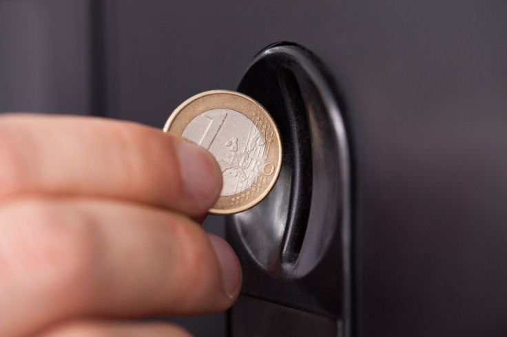Hand inserting coin into vending machine