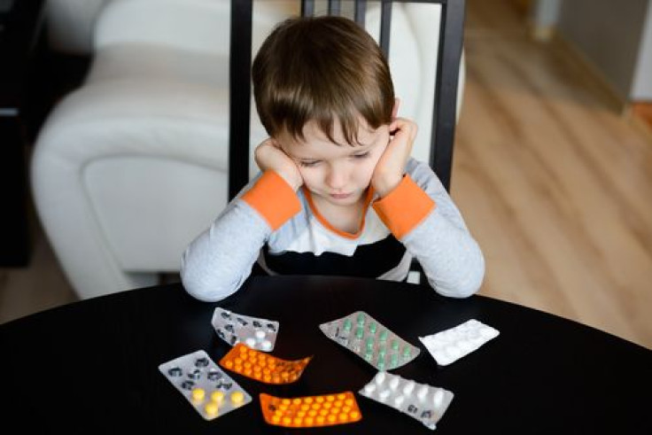 Depressed boy sitting in front of medications 
