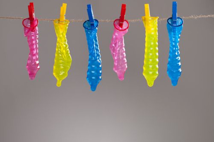 Colorful condoms hanging on rope with clothespins