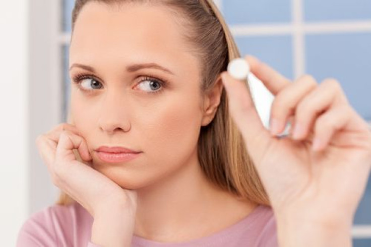 Woman holding pill