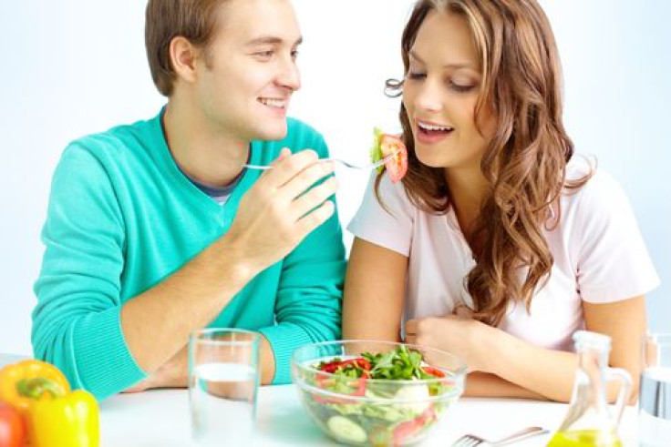 Man feeding woman vegetable salad