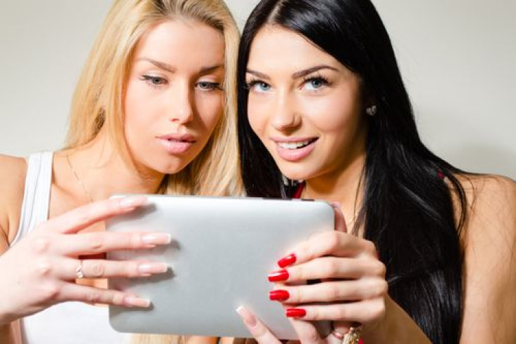 Two women smiling using tablet 