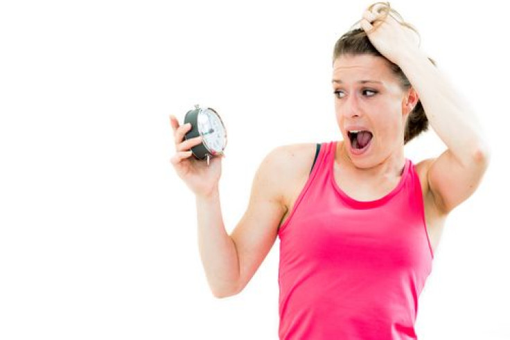 Woman yawning looking at clock