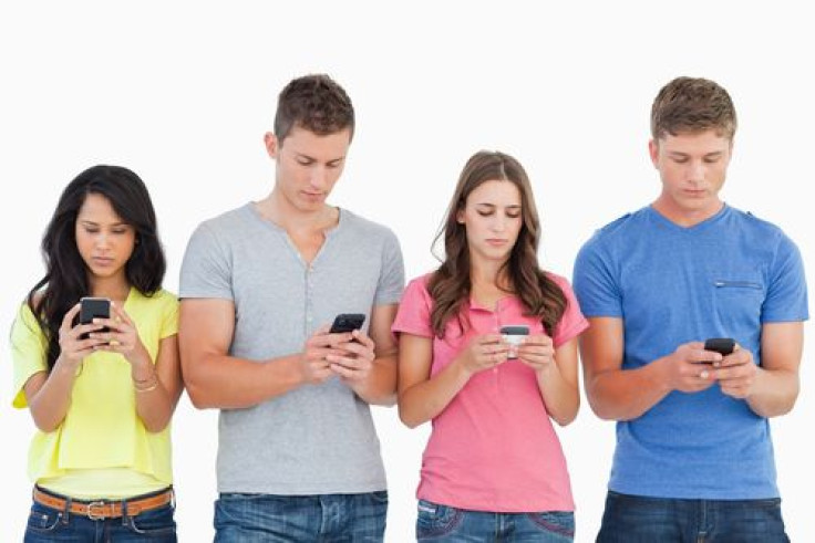 A group of people using their phones to send text messages