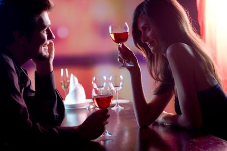 Young couple sharing a glass of wine in restaurant
