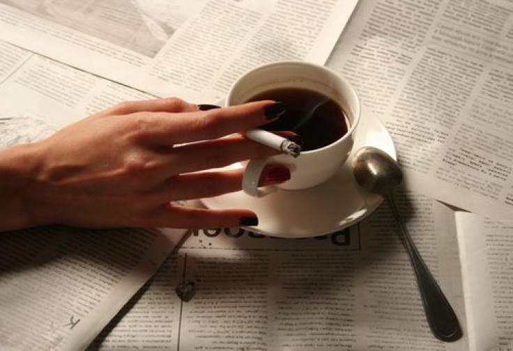 Woman holding cigarette and drinking coffee