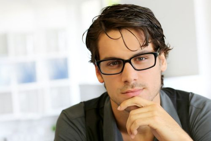 Man wearing glasses with hand under chin