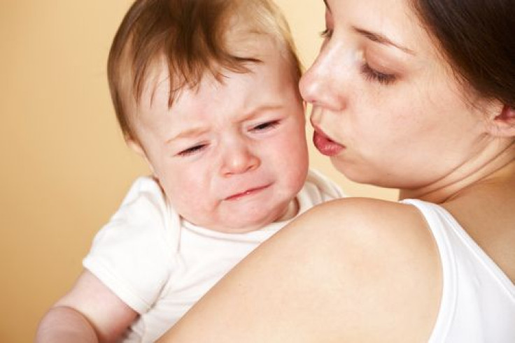 Baby boy crying in mother's arms