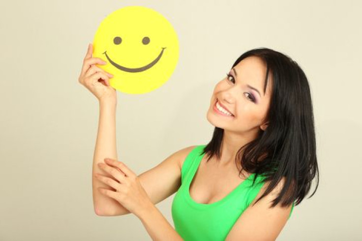 Woman smiling holding smiley face