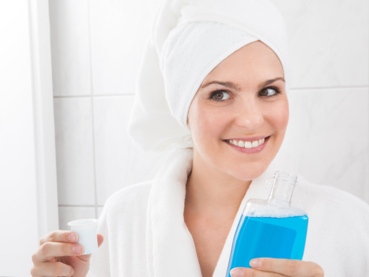 Happy woman holding bottle of mouthwash