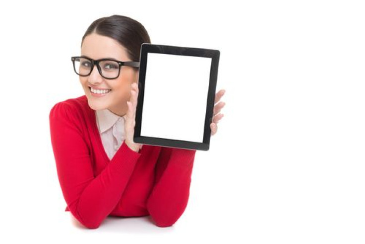 Woman with glasses holding tablet in hand