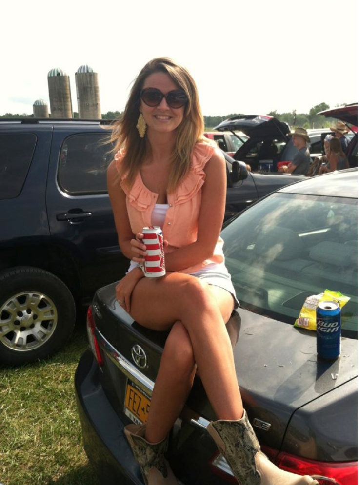 Jenna outside in top of car drinking 