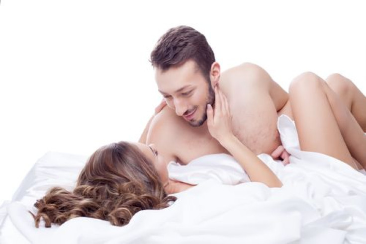 Man smiling looking at woman in bed