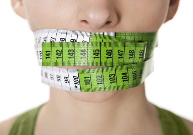 Woman with measuring tape over mouth