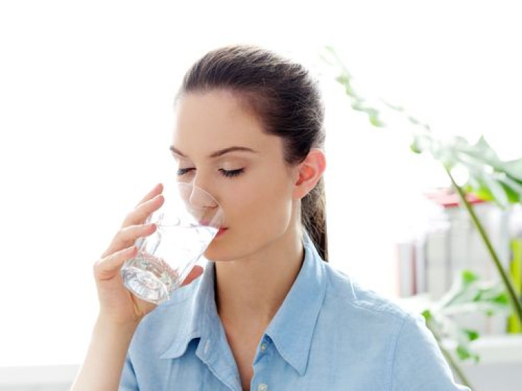 Woman drinking glass of water in the morning