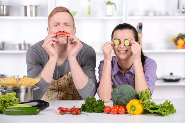 Couple playing with food in kitchen