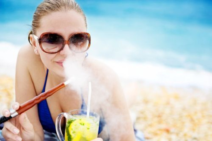 Woman on beach smoking hookah