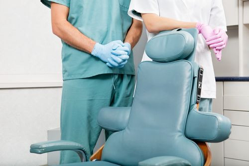 Dentist and assistant surrounding dentist chair
