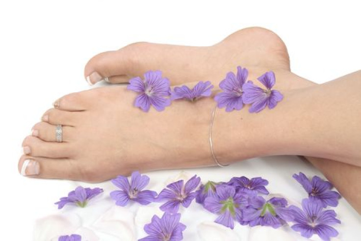 womans-feet-crossing-each-other-purple-flowers-sides