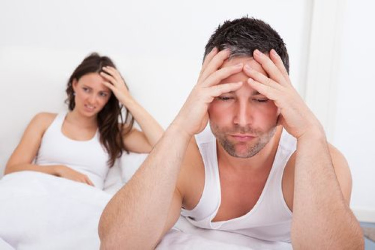 Frustrated man sitting on bed in front of woman