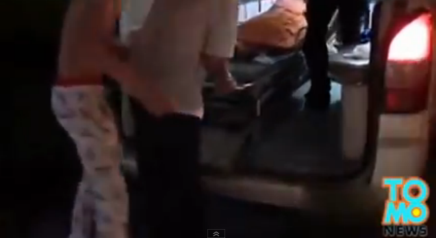 Driver in pajamas going into ambulance