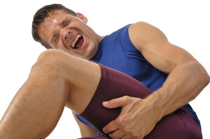 Male athlete clutching his hamstring in excruciating pain