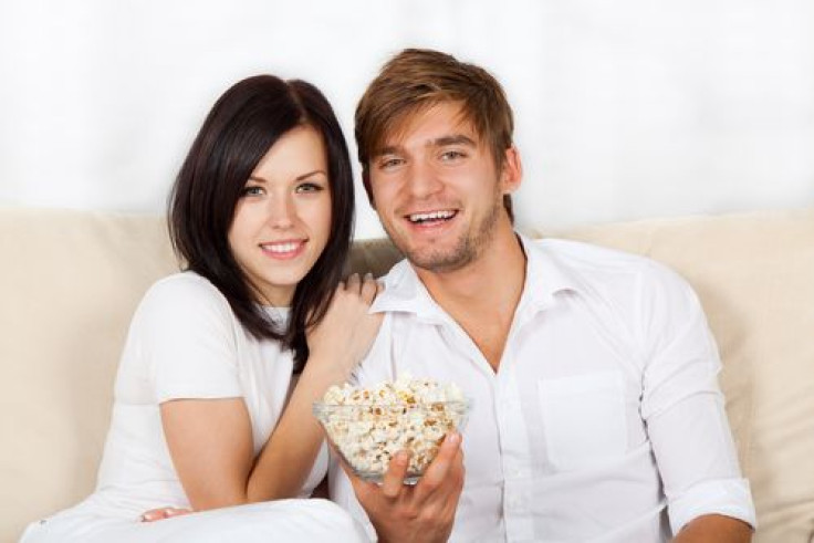 Couple watching TV and eating popcorn