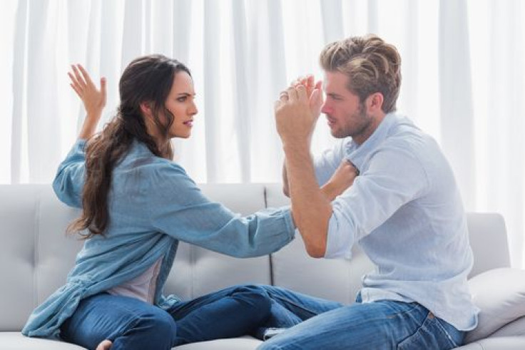 Upset woman about to slap her partner the living room
