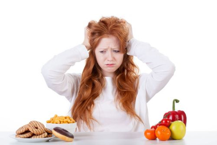 Woman holding hands to head looking at food